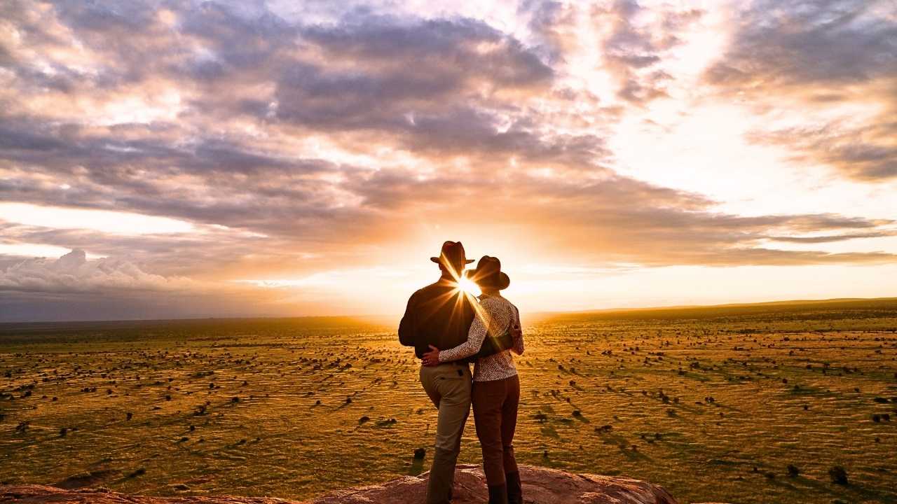 Romantic couple arm in arm overlooking an African sunset