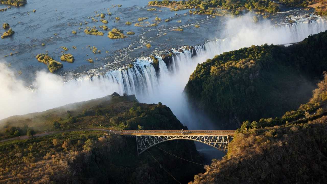 Aerial Shot of Victoria Falls with bridge in foreground in summer.
