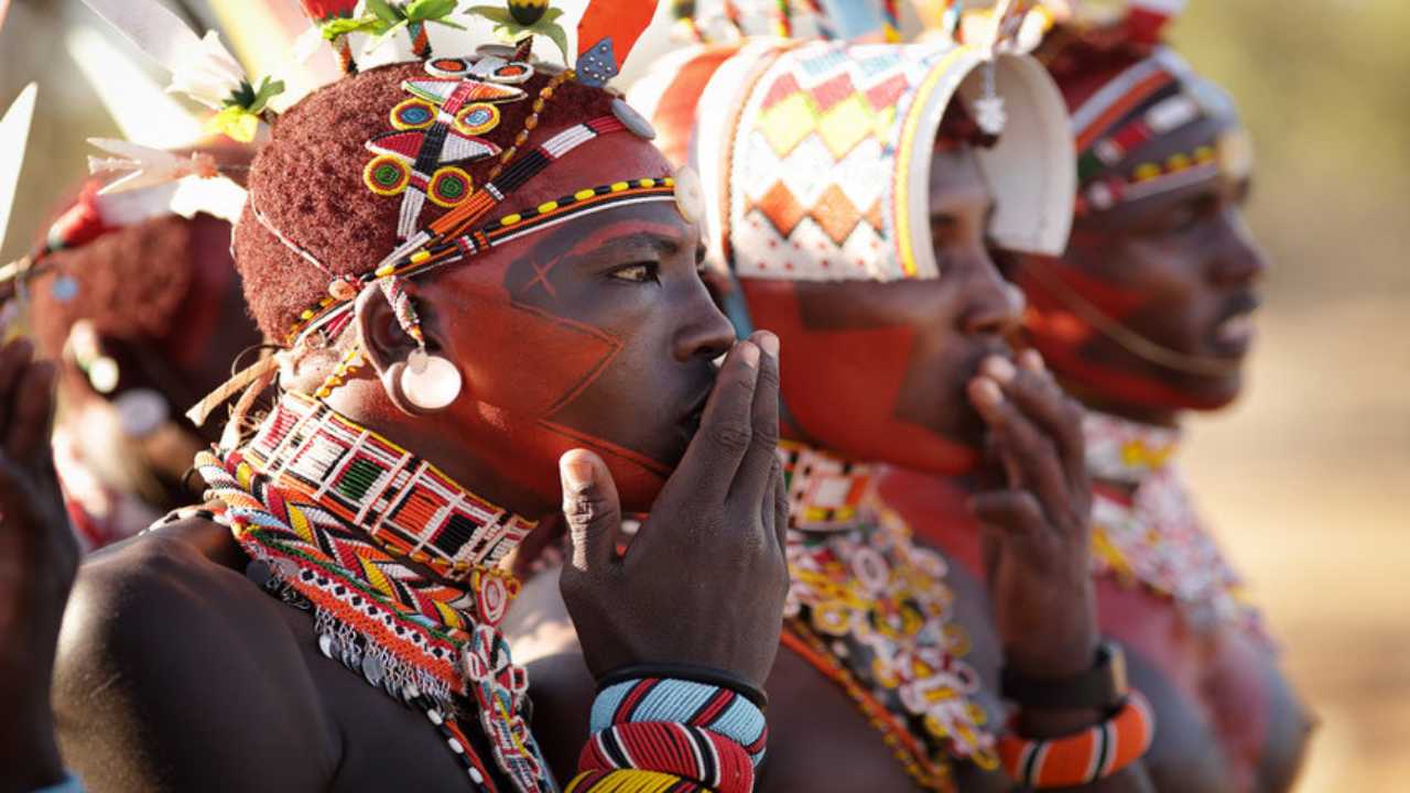 Colourfuly painted traditional tribal woman from Africa wearing bangles and necklaces made of beads