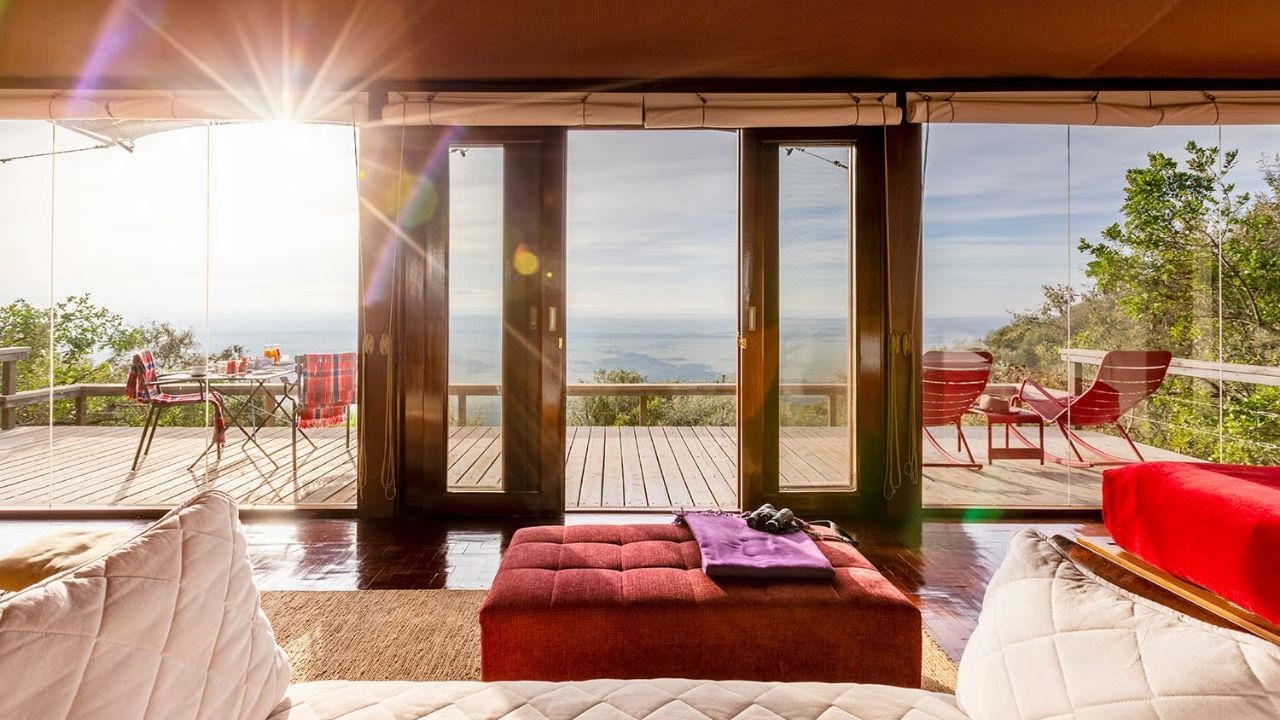 Deck view with sunlight entering guest suite at Angama Mara Safari Camp, Maasai Mara, Kenya.