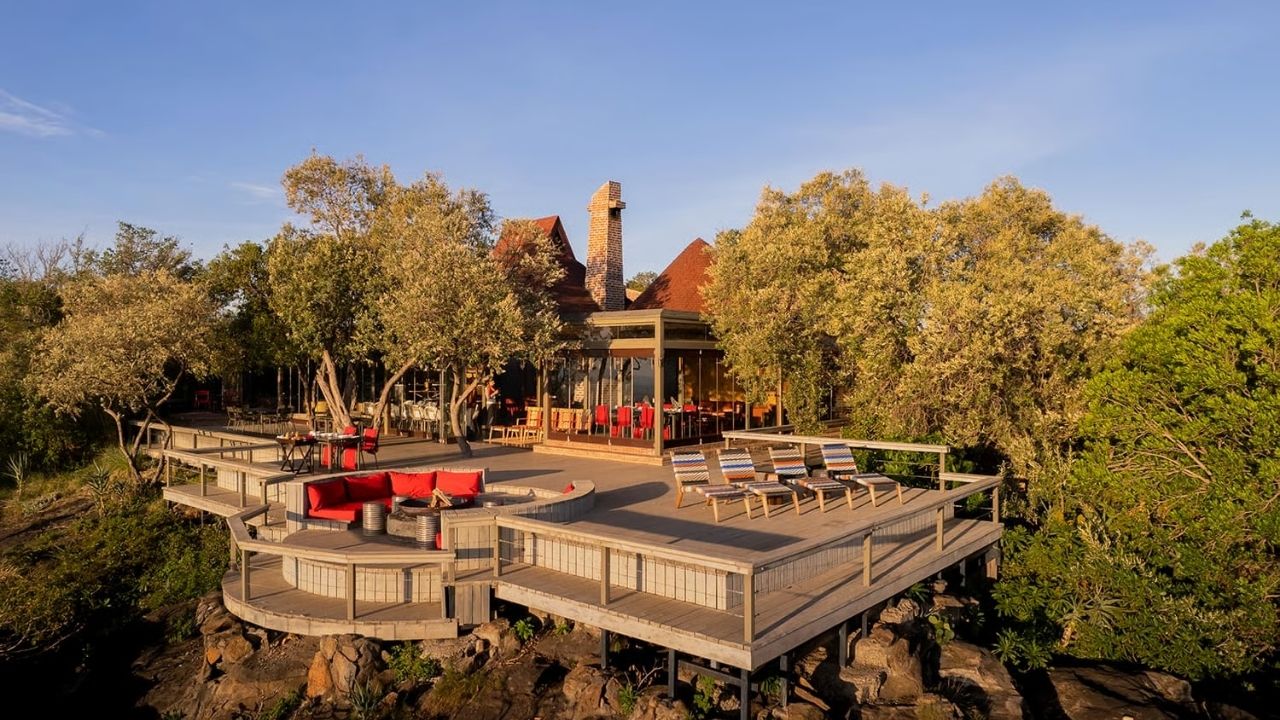 Aerial view of deck and firepit at Angama Mara Safari Camp, Maasai Mara, Kenya, with dining area in background.