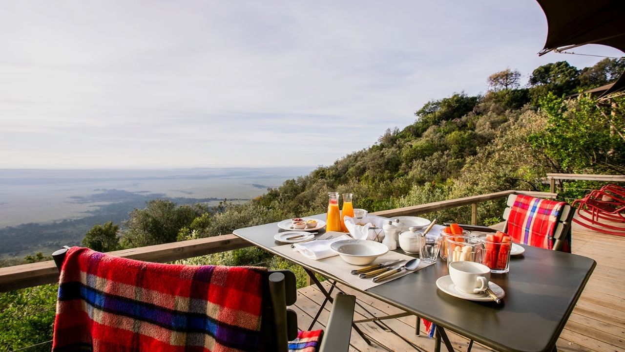 Breakfast table set on deck at Angama Mara Safari Camp, overlooking Maasai Mara plains, Kenya.