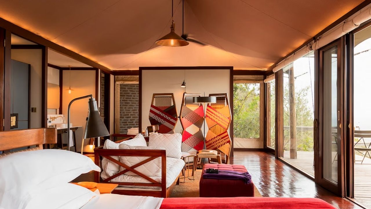 Lounge area inside a guest room at Angama Mara Safari Camp, Maasai Mara, Kenya, with bush views.
