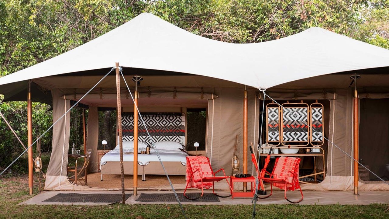 Front view of Angama Safari tented suite with open doors, Maasai Mara, Kenya, showing deck and bush views.