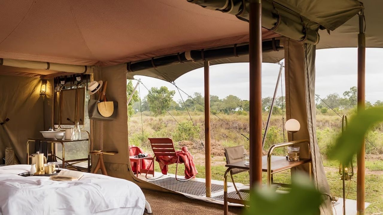 View from inside tented suite at Angama Safari, looking out onto deck and Maasai Mara bush, Kenya.