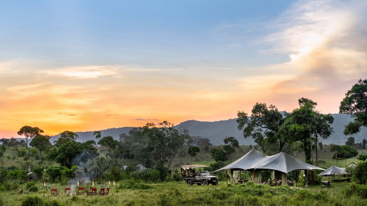 Sunset over mountains at Angama Safari Camp, Kenya, with tented suites in the distance.