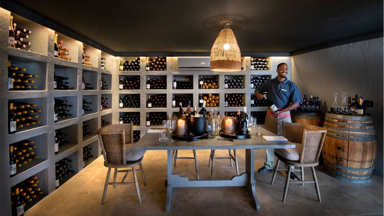 Wine cellar at Sossusvlei Desert Lodge with host pouring red wine