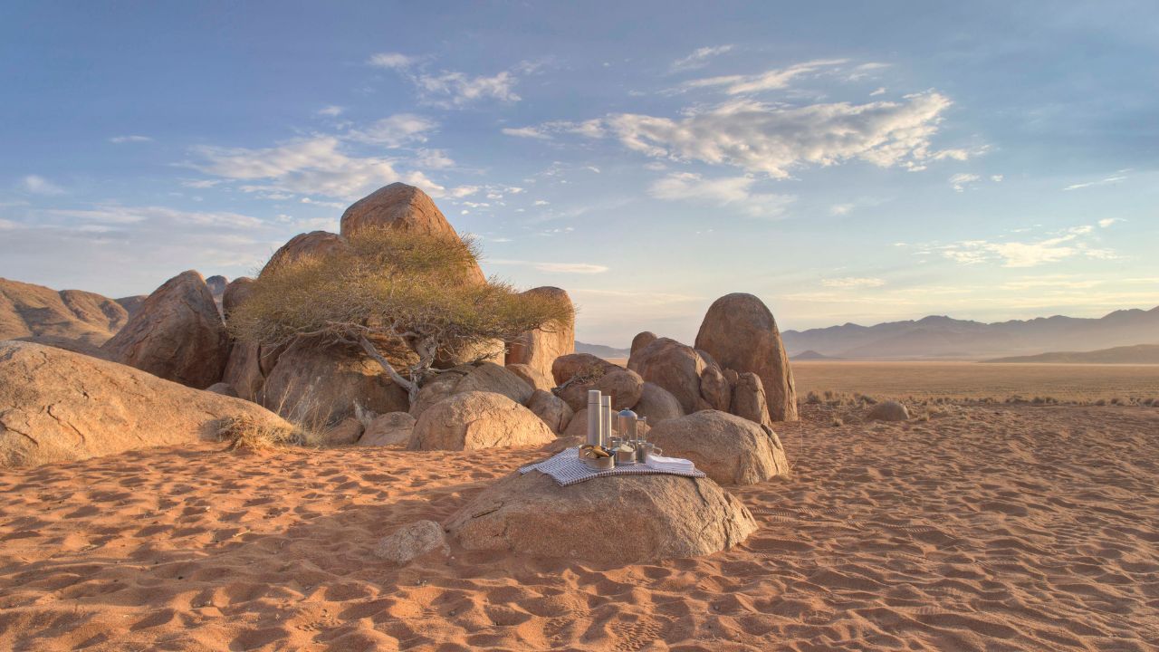 Sunset drinks setup on rock with desert views at Sossusvlei Desert Lodge