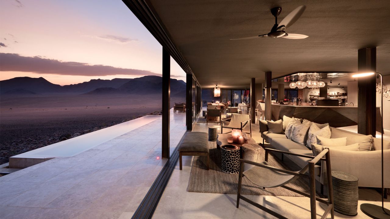 View from lodge deck over desert with pink skies at sunset, Sossusvlei Desert Lodge