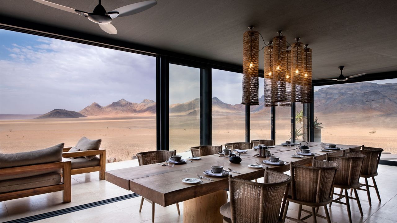Dining area at Sossusvlei Desert Lodge with large bay windows overlooking desert