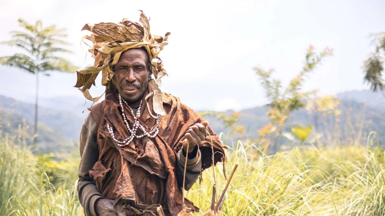 Batwa man in traditional dress facing camera