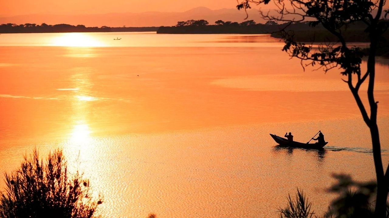 Golden sunset over Lake Mutanda with mountains in background