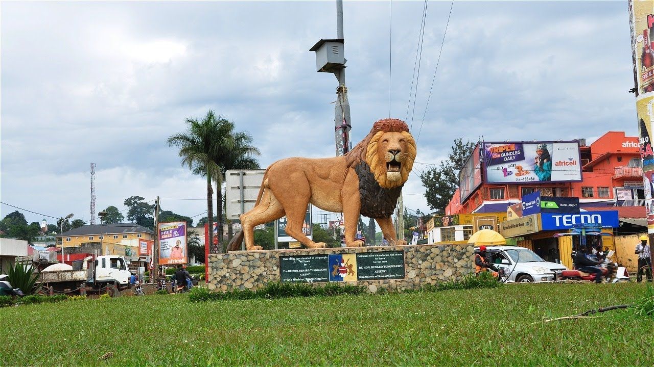 Statue of a lion at Fort Portal, Uganda with the city in the background