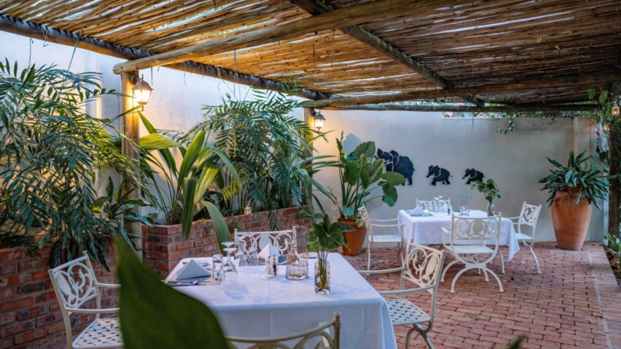 Outdoor dining area at Batonka Hotel with tables and greenery
