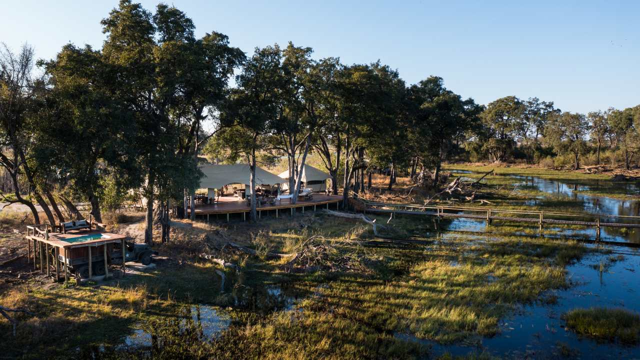 Aerial view of Duba Explorers Camp in Botswana’s Okavango Delta with waterways in the foreground and the main lodge nestled behind.