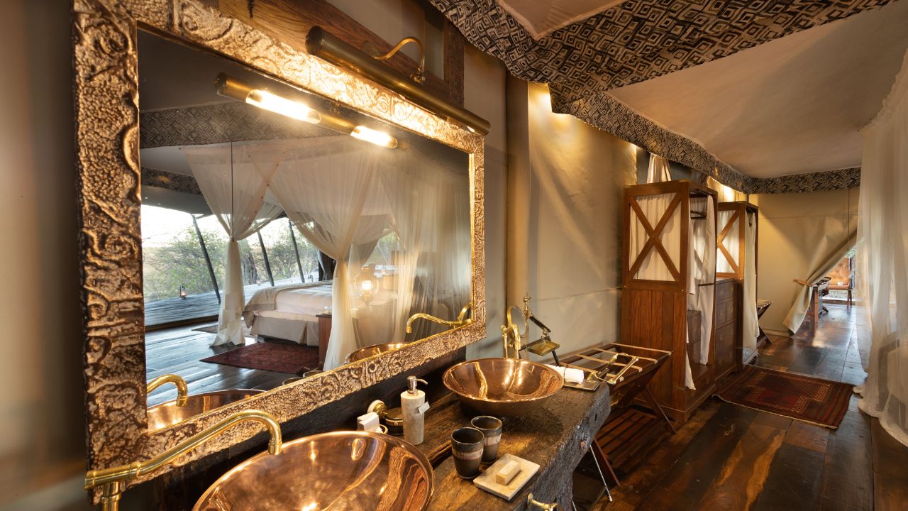 View of guest bathroom with large mirror and twin basins in luxury Zarafa Camp suite