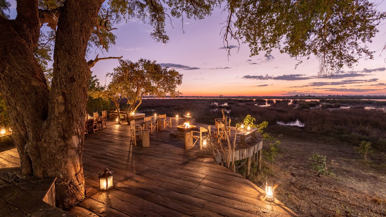 Private dining area lit with candles, sunset view at Zarafa Camp