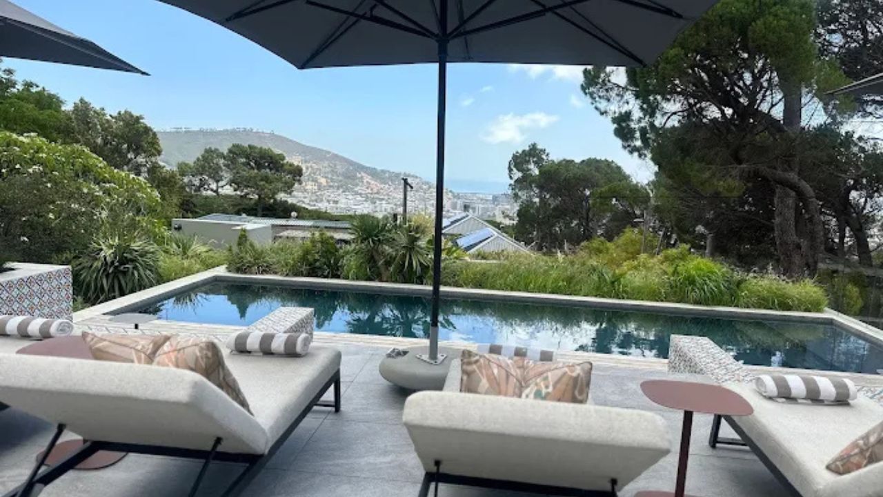 Deck view over Cape Town city with lounge chairs and swimming pool at Camissa House