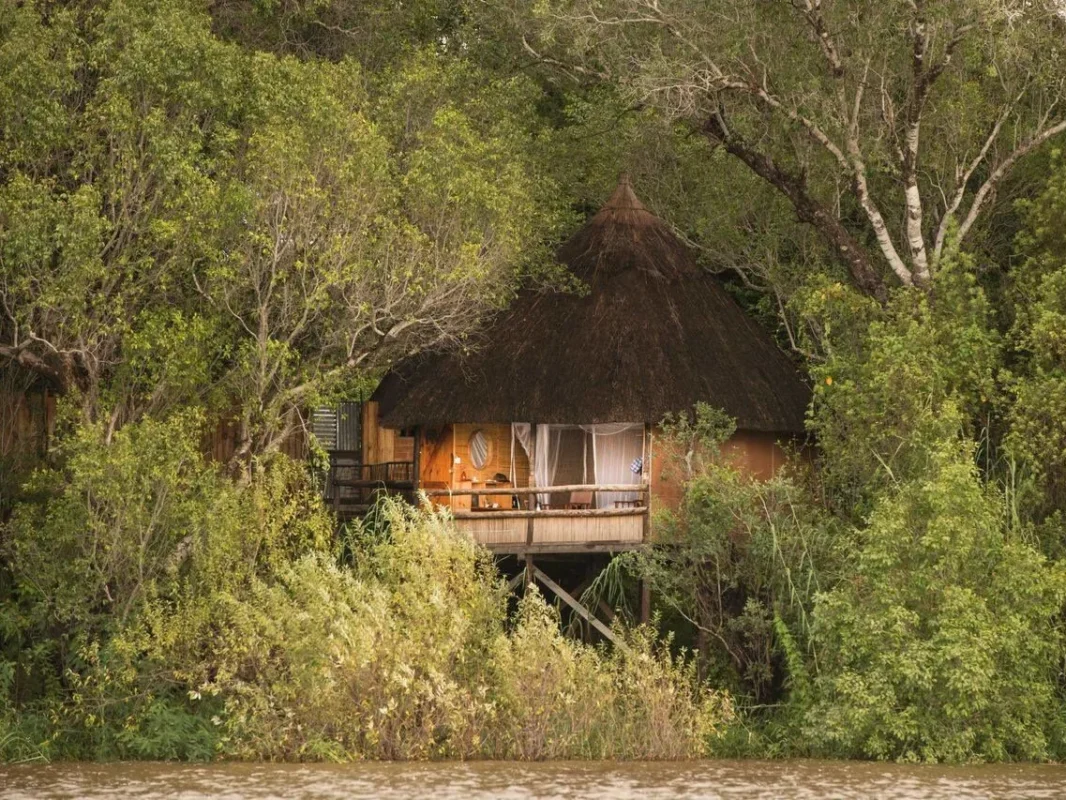 Chundukwa Lodge view from across the river, lodge with lights on in the distance across river in Zambia.