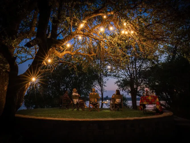 Chundukwa Lodge Zambia at night on main deck with candles burning in holders in trees