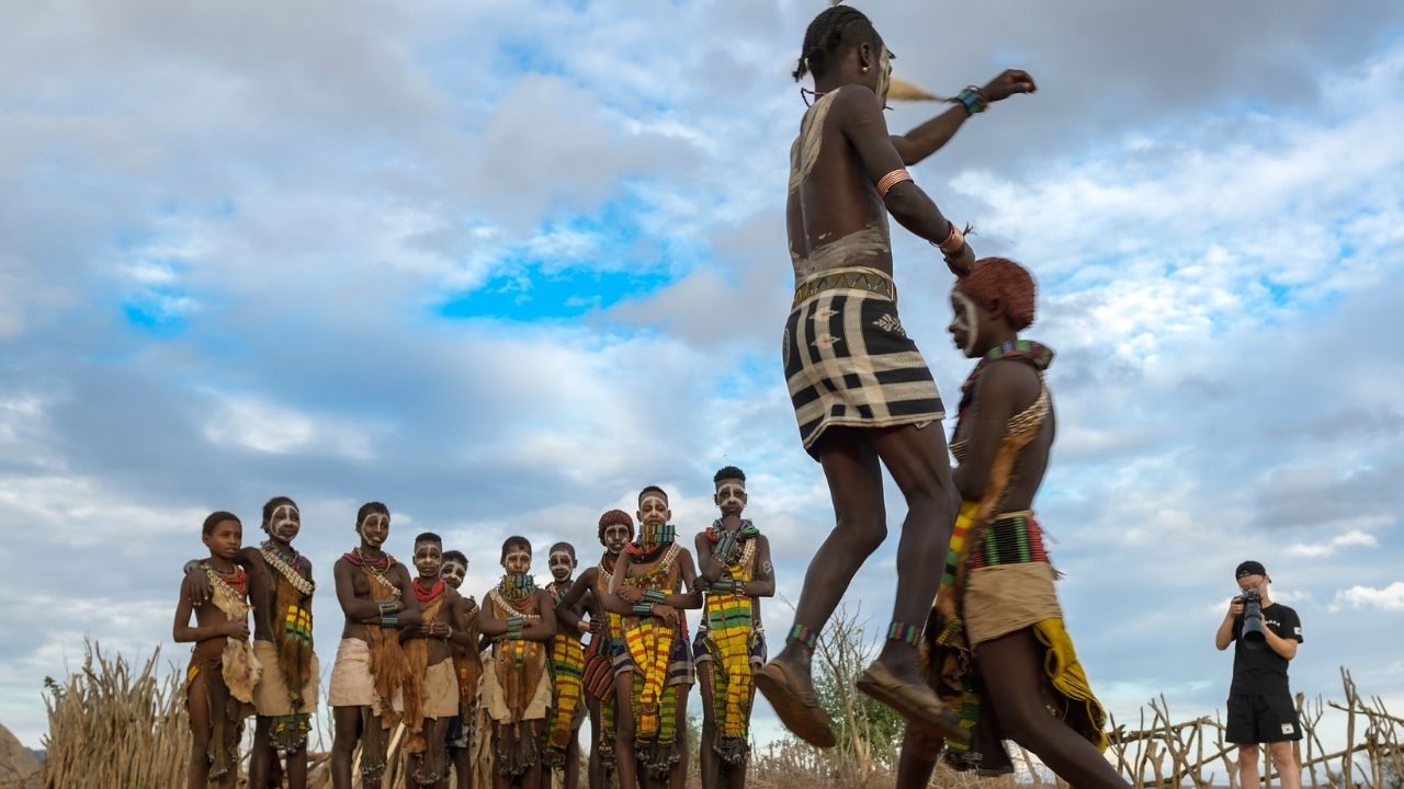 Traditional Ethiopian men performing dance with one jumping in the air