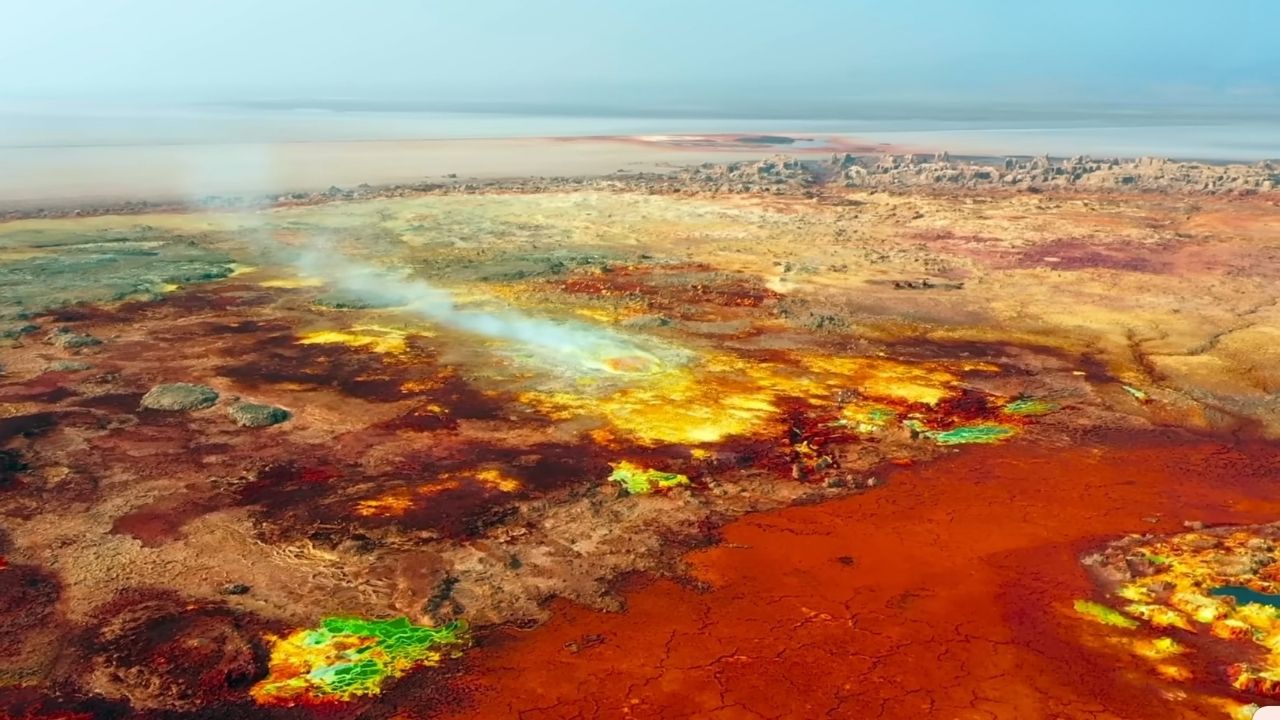 Aerial view of Danakil Depression with bright green, yellow and red earth tones.