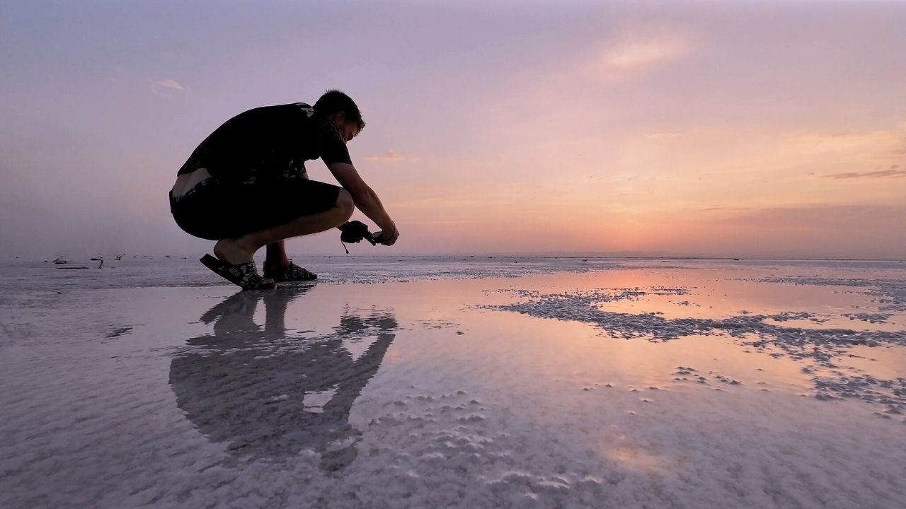 Photographer capturing sunset reflections in Danakil Depression, Ethiopia