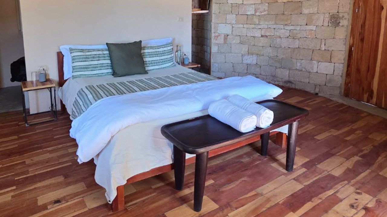 Double bed with white linen and wooden floor, Korkor Lodge Ethiopia
