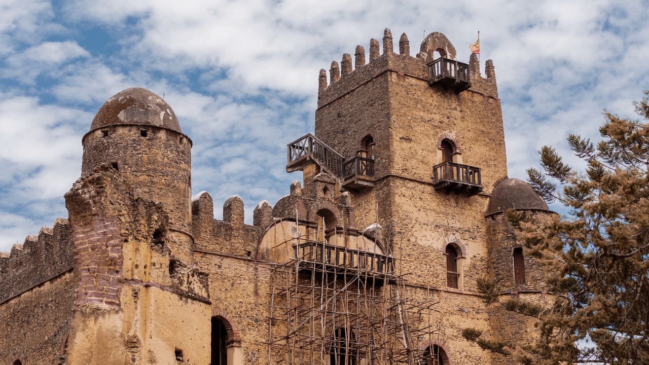 Gondar castle with wooden scaffolding undergoing repairs on damaged walls, Ethiopia.