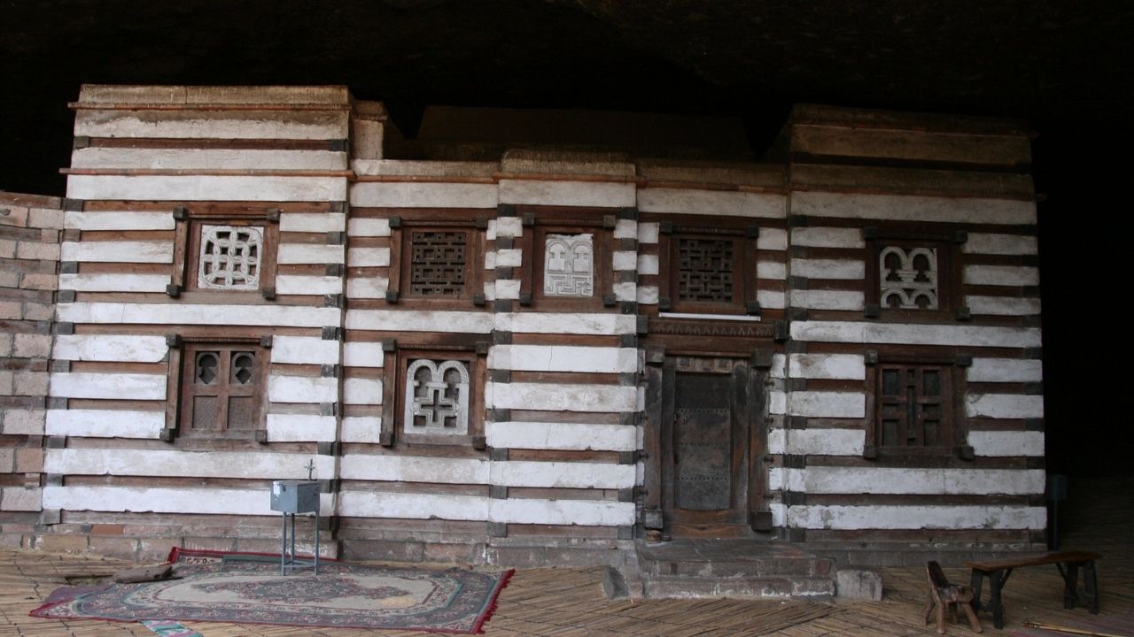 Front view of Yemrehana Cristos Church with stone façade and green surroundings, Ethiopia.