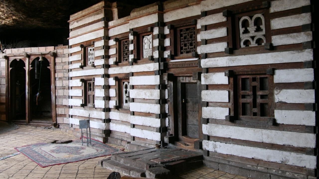 Side-angle view of Yemrehana Cristos Church showing architectural details and roofline, Ethiopia.