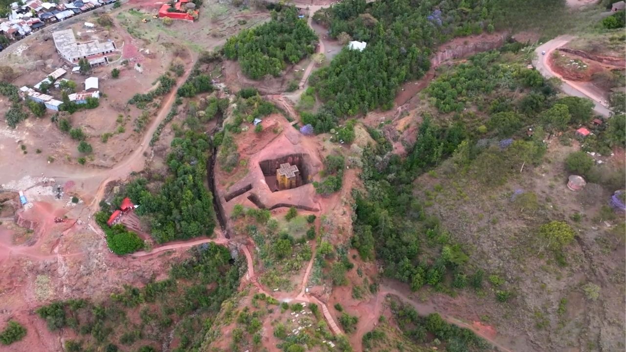 Very high-angle aerial shot of Lalibela church locations and surrounding mountains.