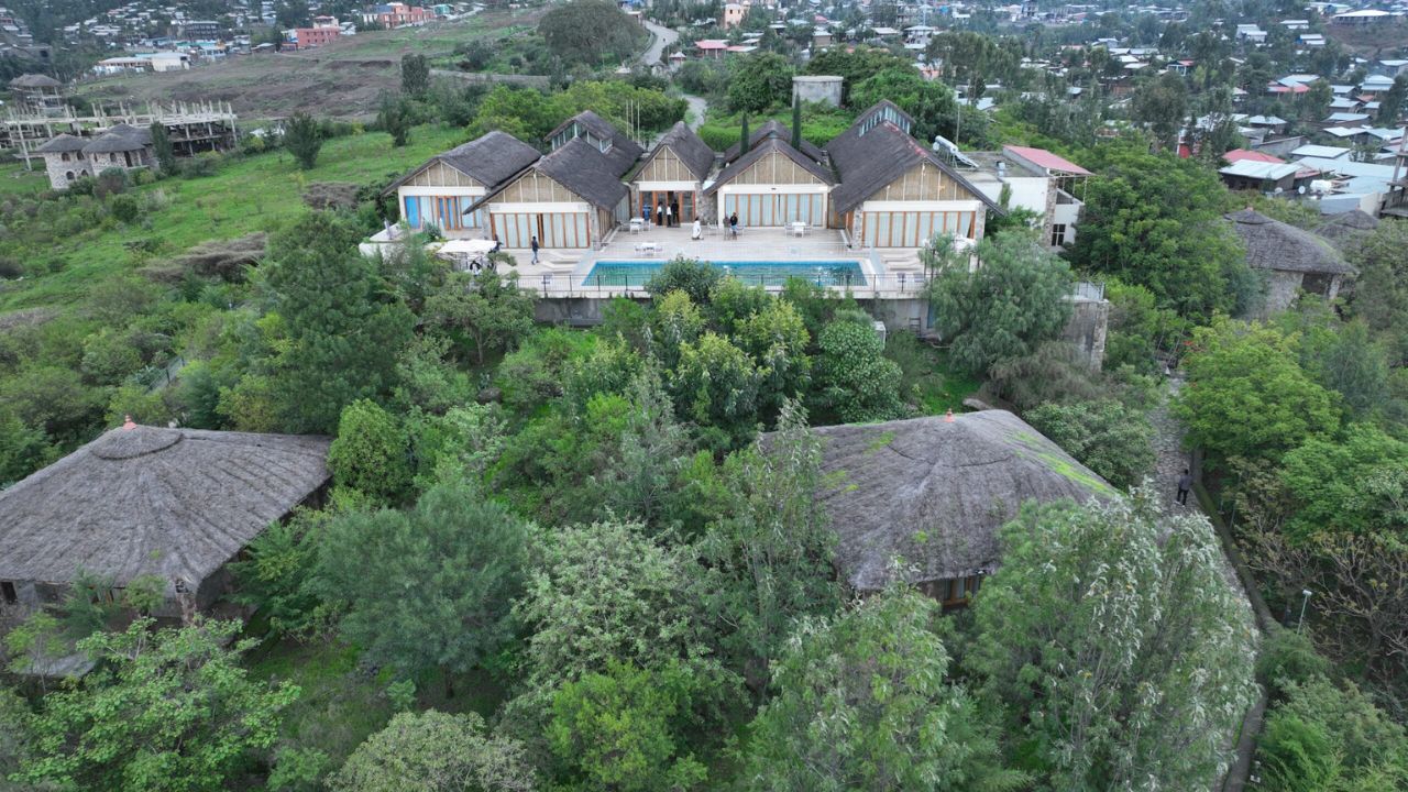 Front aerial view of Mezena Lodge nestled on hill, Ethiopia