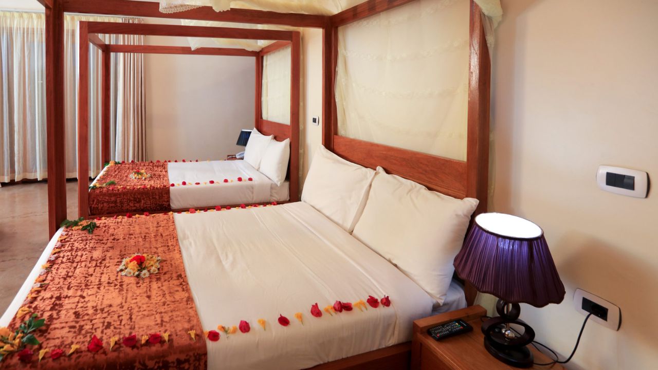 twin room in Mezena lodge, wood trimmings on twin beds. Whit linen