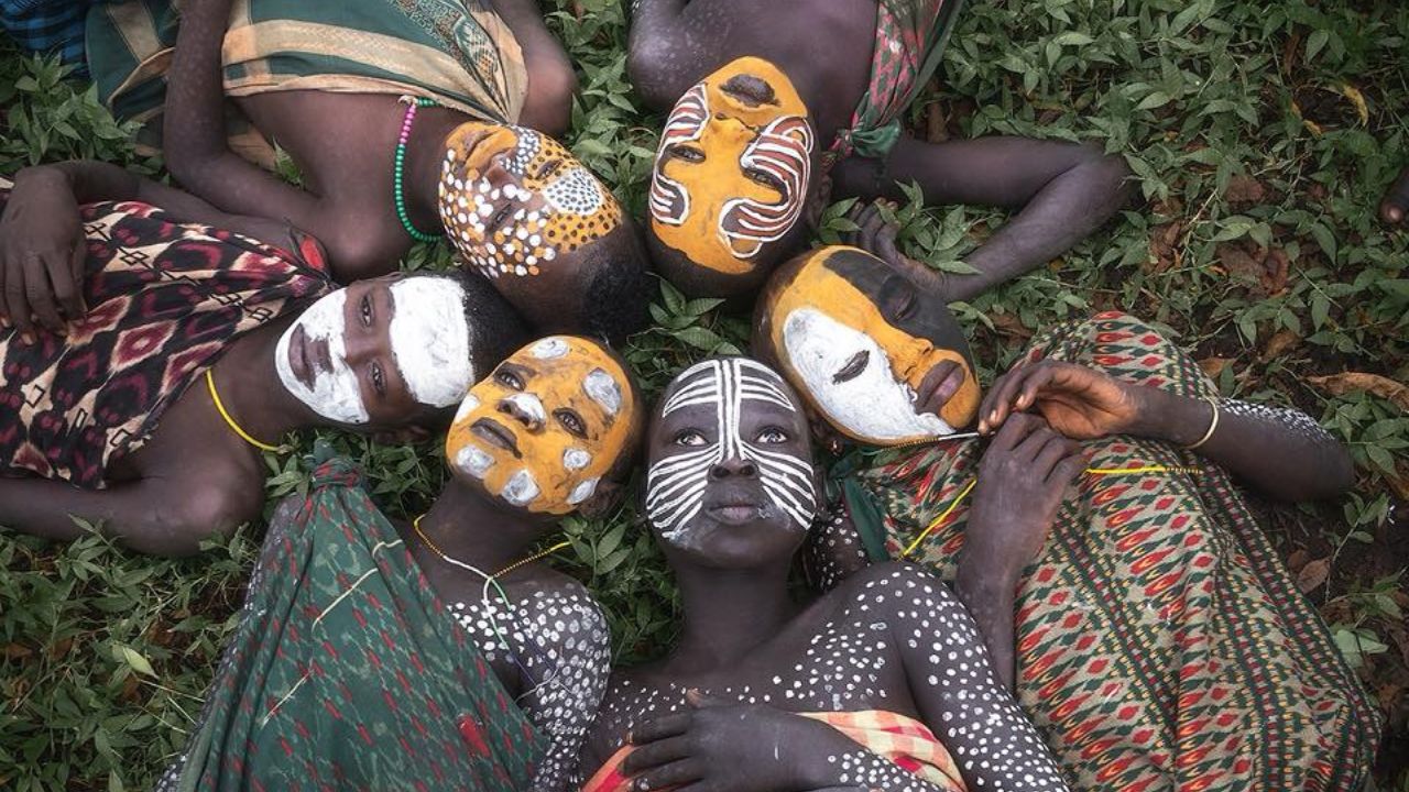 Omo Valley children with painted faces lying in circle