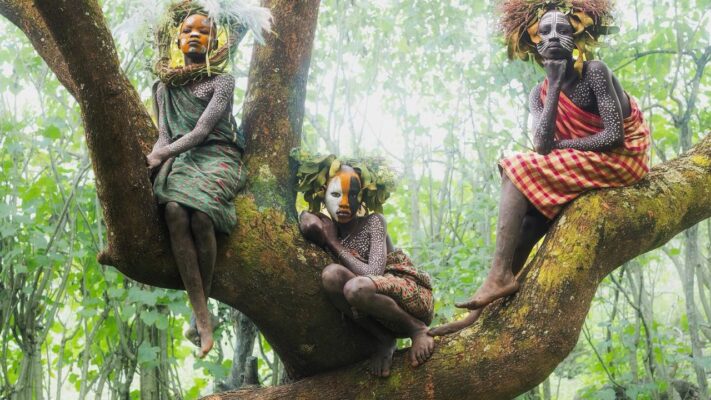 Omo Valley girls in tree branches with painted faces