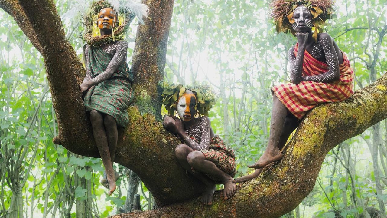 Omo Valley girls in tree branches with painted faces