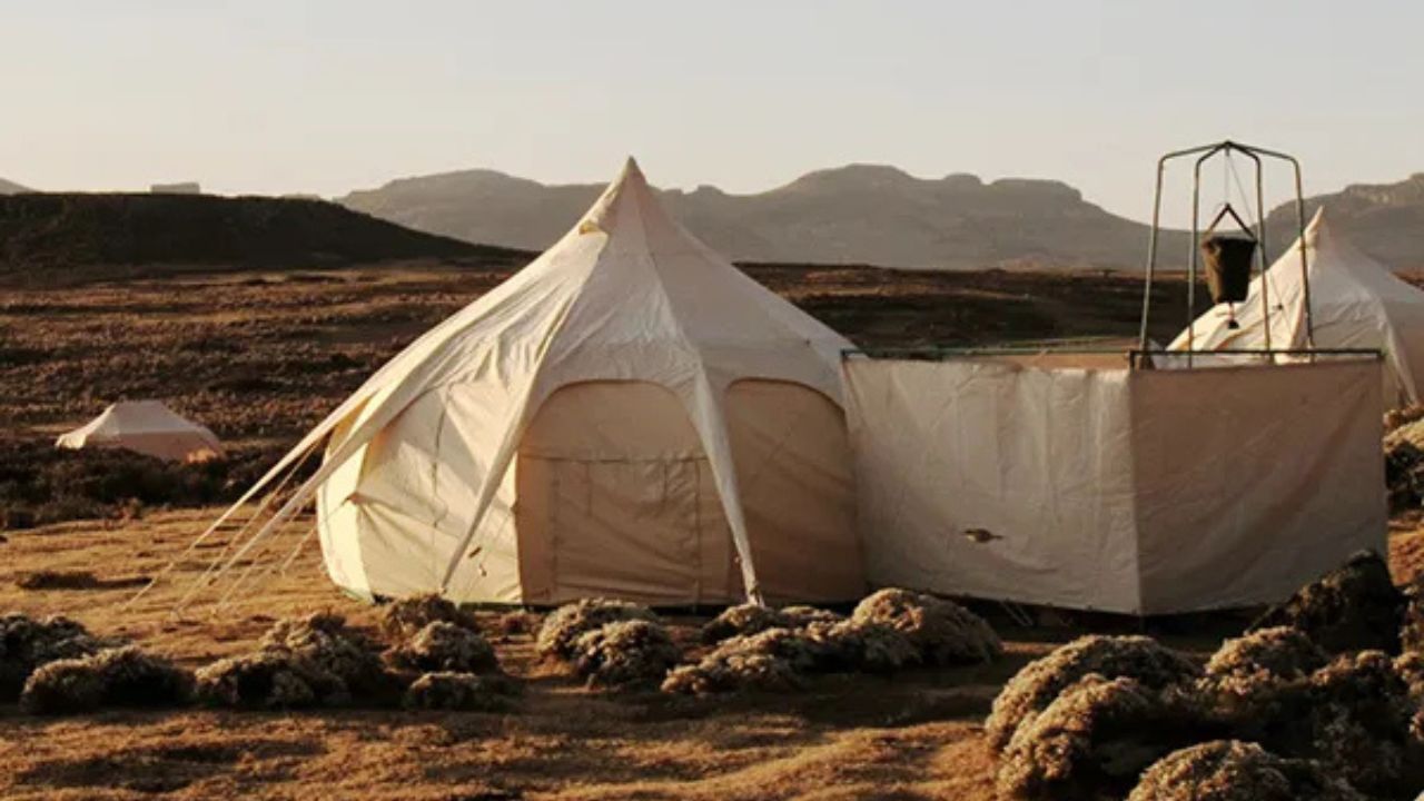 Luxury tented camp in the Bale Mountains, Ethiopia, with twin beds, en-suite shower, and wooden furnishings.
