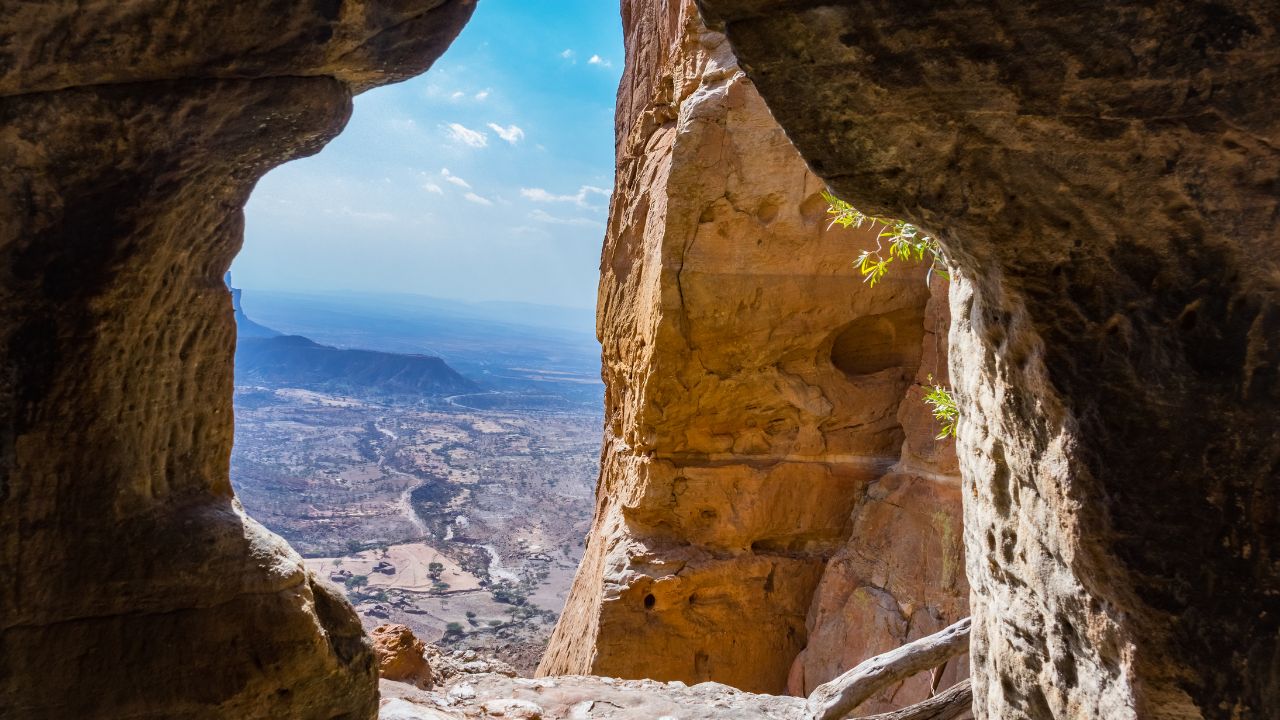 View through cave hole of Abuna Yemata Guh monastery looking out over valley below, Tigray.