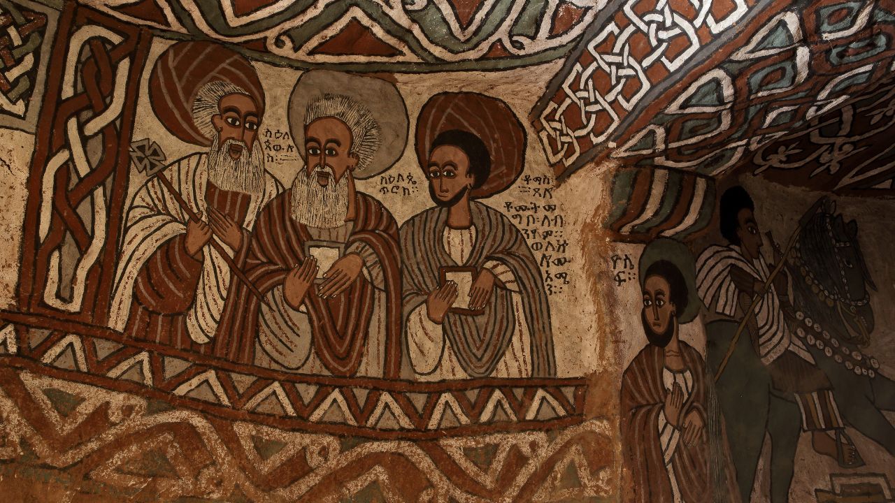Fresco painting of disciples in browns, greys, and blacks with white trim inside Abuna Yemata Guh.
