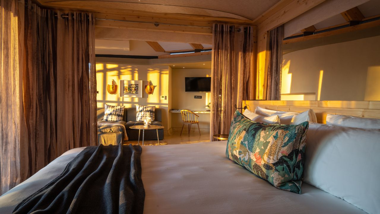 Guest room side view with double bed, soft lighting, and modern finishings
