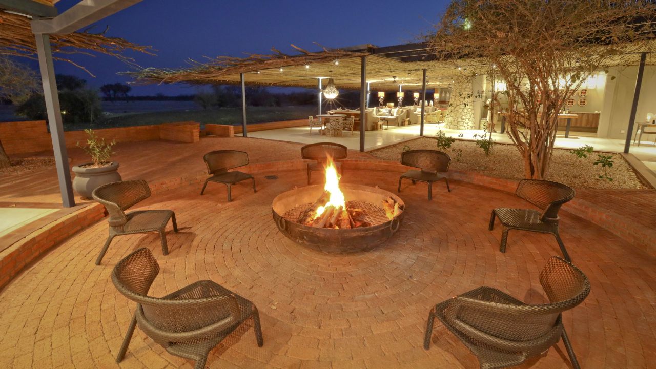 Front view of main lodge at night with boma fire and fully lit buildings