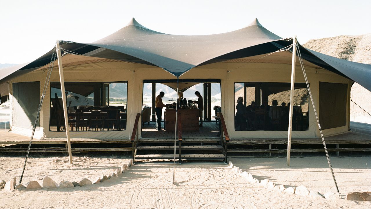 Main lodge interior during daytime with guests enjoying breakfast
