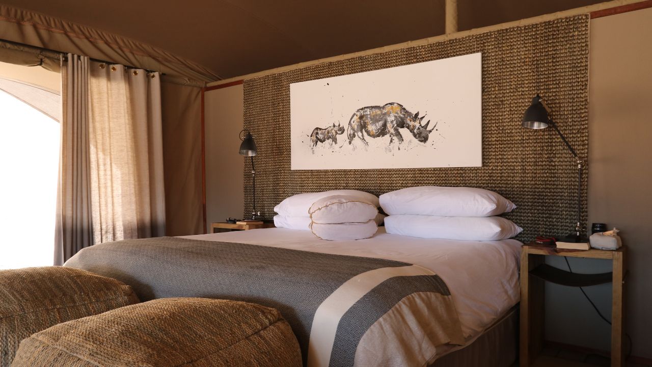 Interior of guest suite with bespoke African design, white linen and khaki green accents