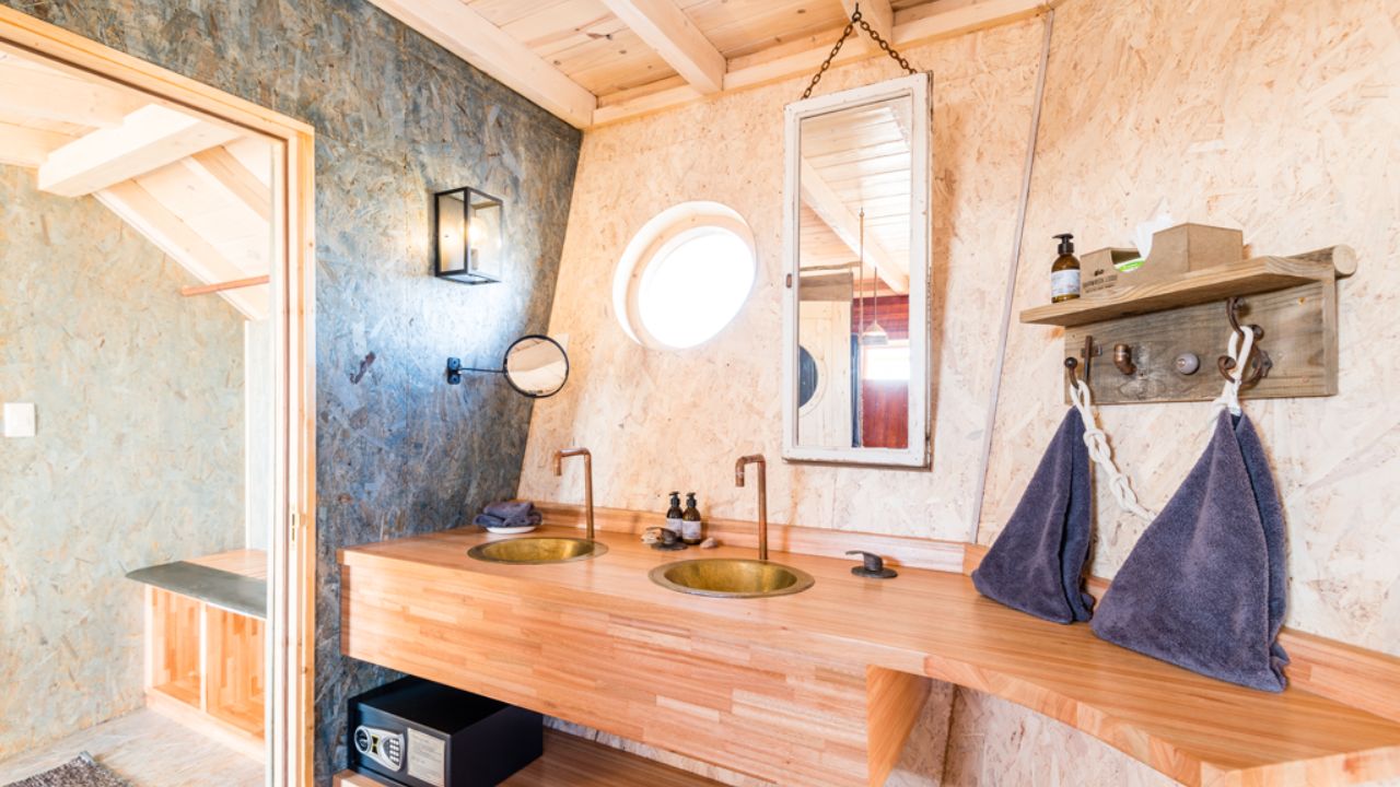 Guest bathroom at Shipwreck Lodge with twin basins and wood finishings