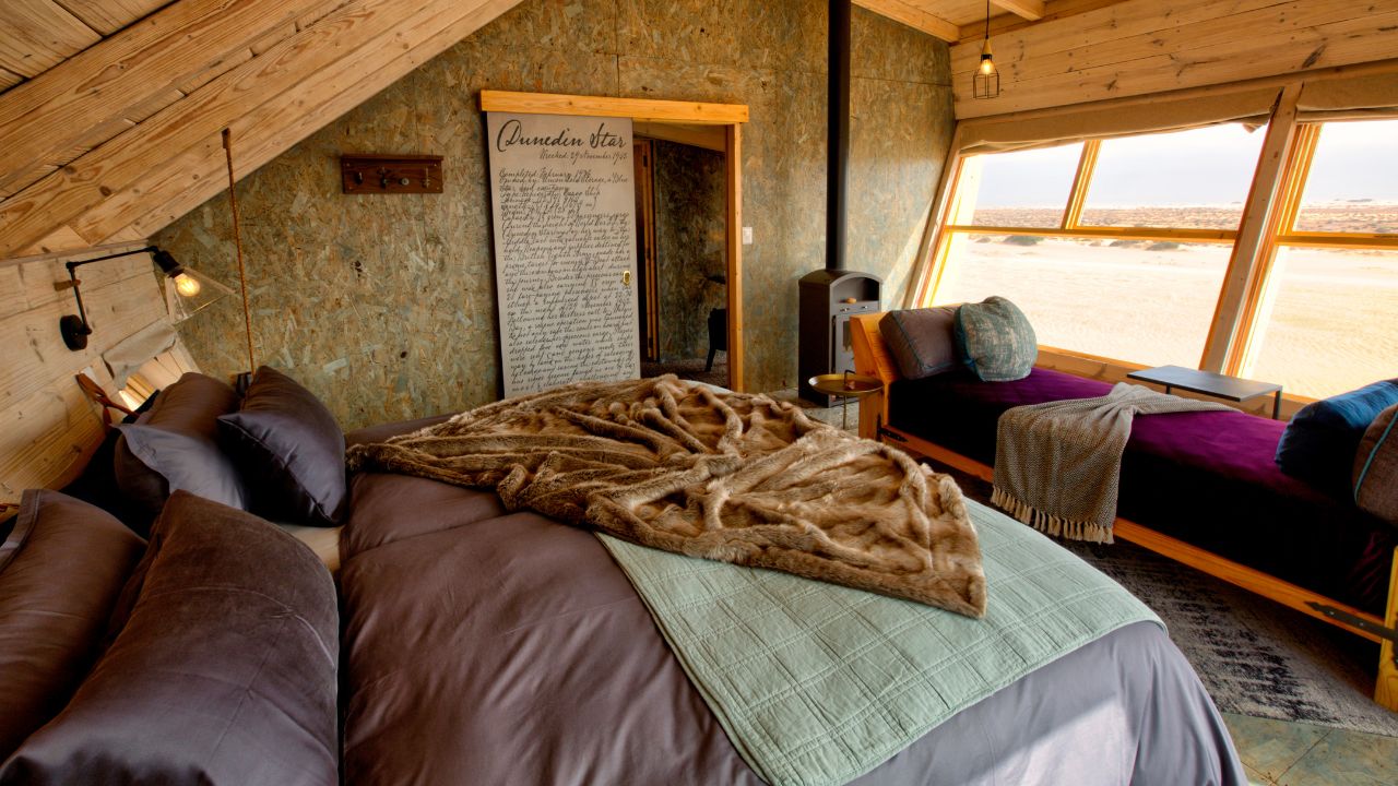 Guest room with double bed and view through window at Shipwreck Lodge