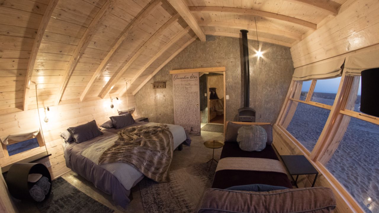 Guest room interior with modern décor, light wood and gray finishes at Shipwreck Lodge