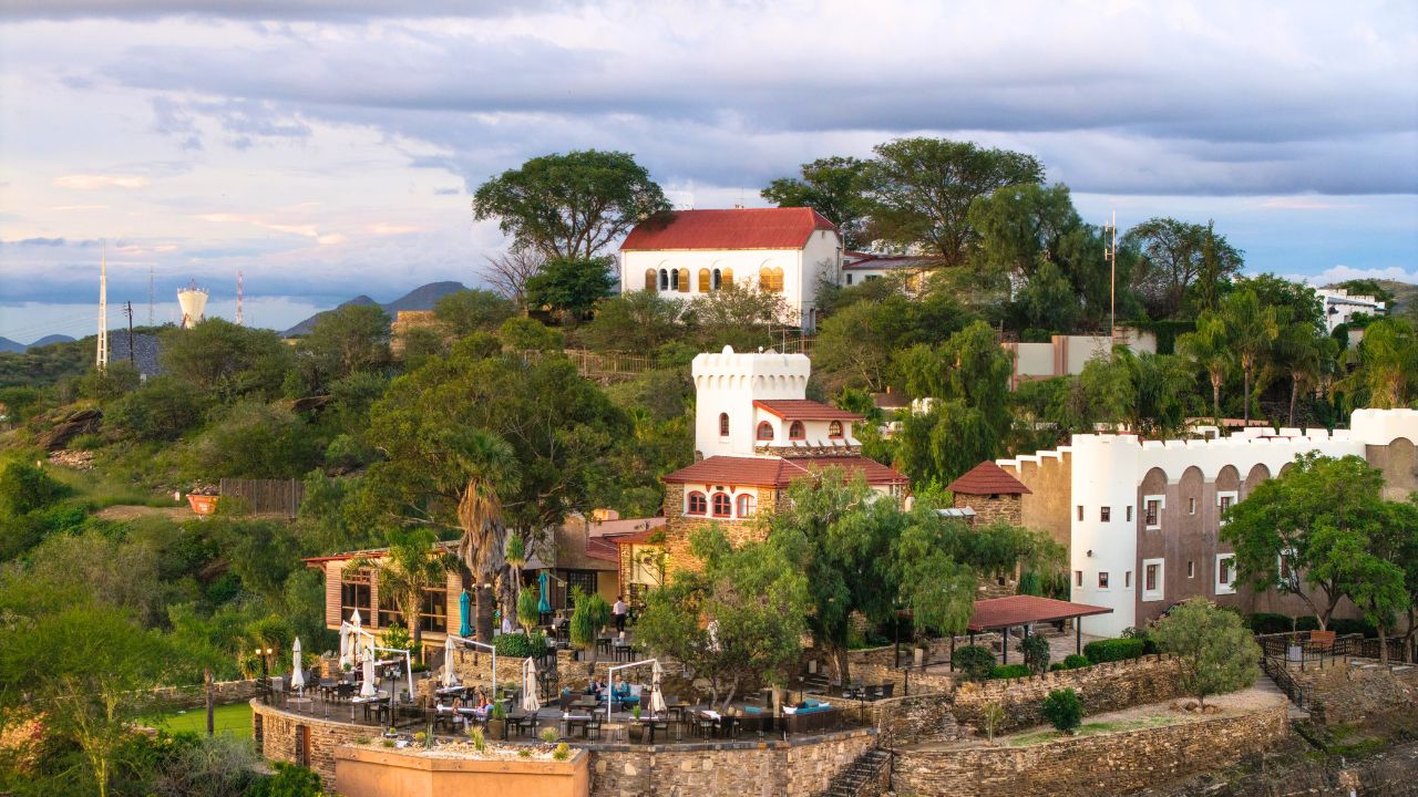 Aerial shot of Heinitzburg Boutique Hotel on hill with guest terrace in foreground