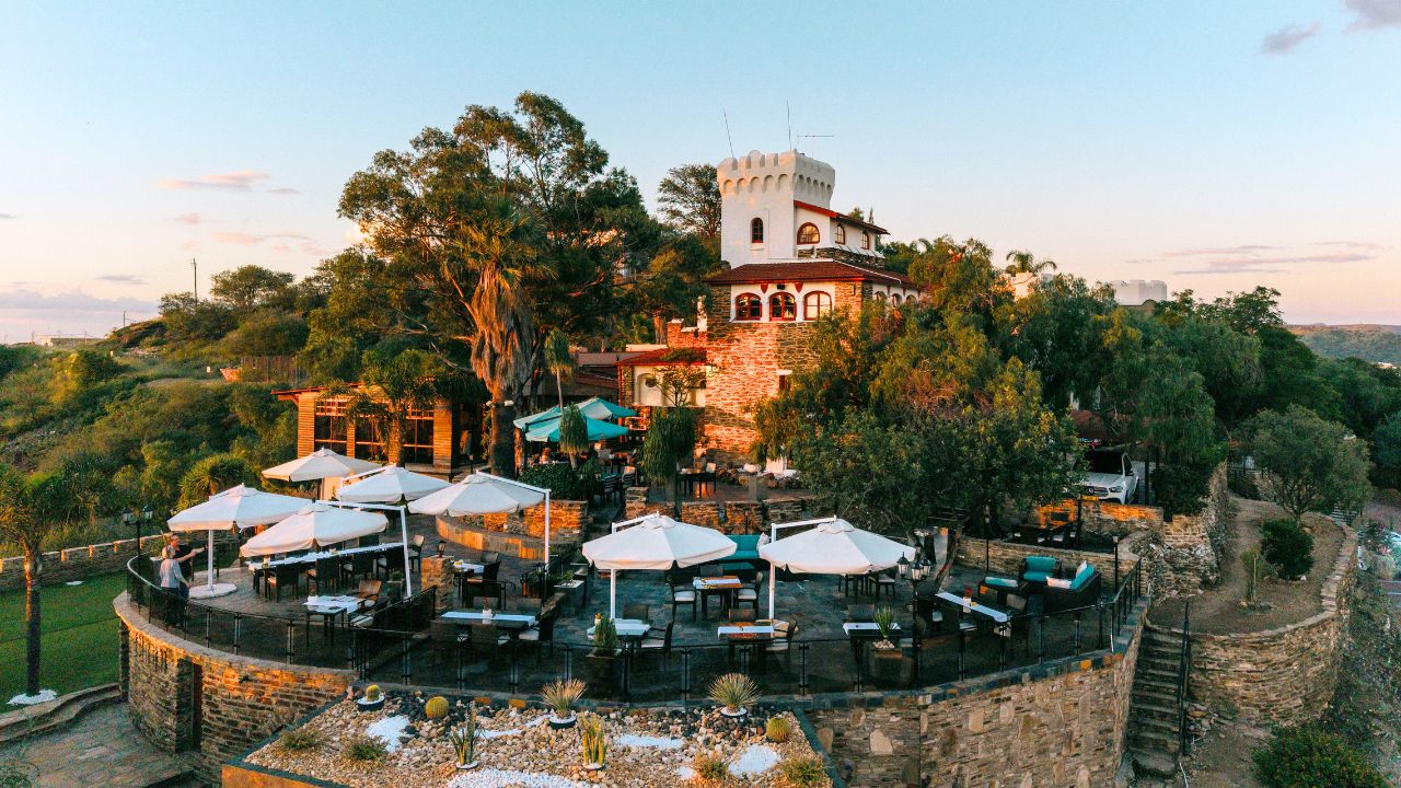 Exterior of Heinitzburg Boutique Hotel at sunset with sunlight on brick facade