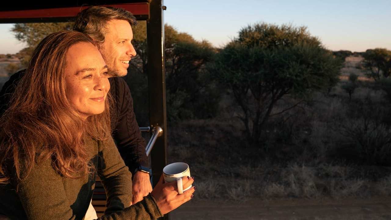 Couple looking out window on Rovos Rail luxury train during Namibia-South Africa tour